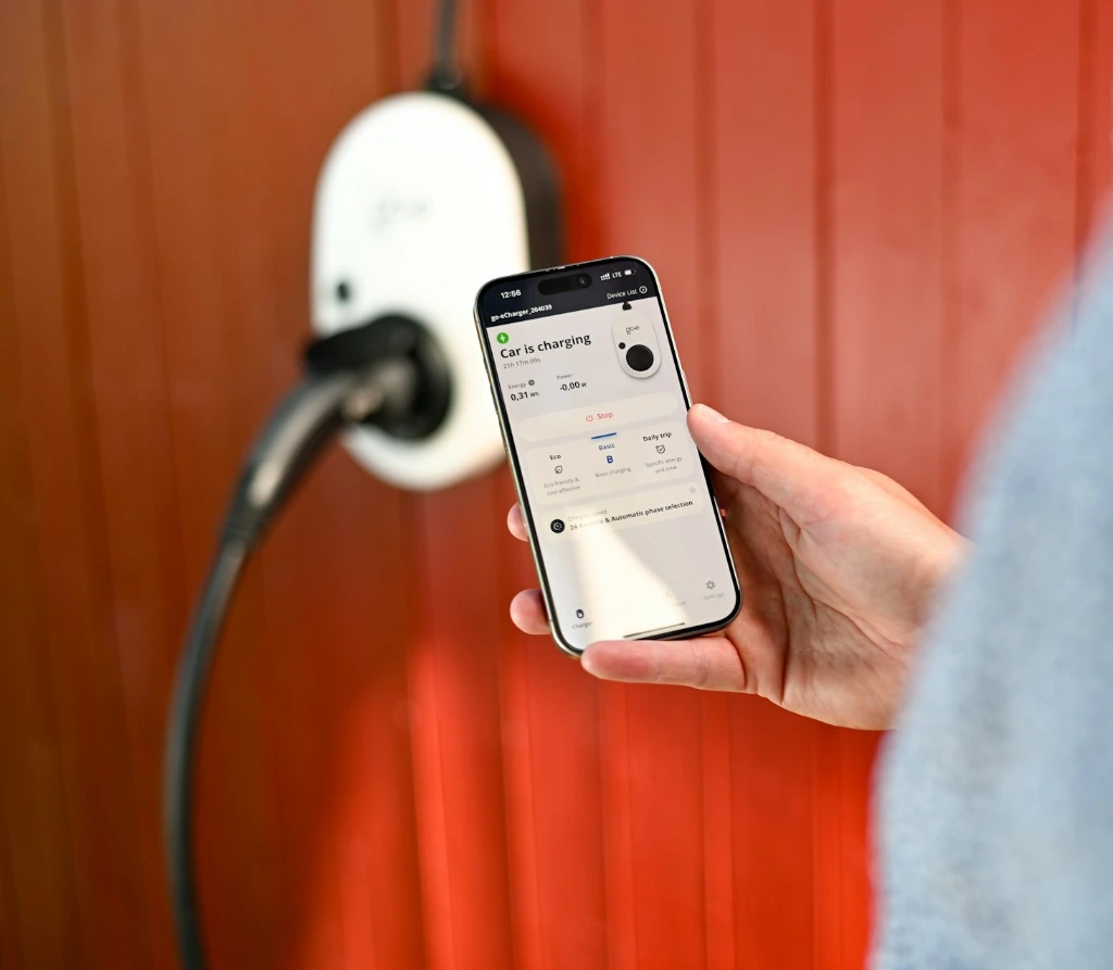 Person uses phone to control electric vehicle charger.